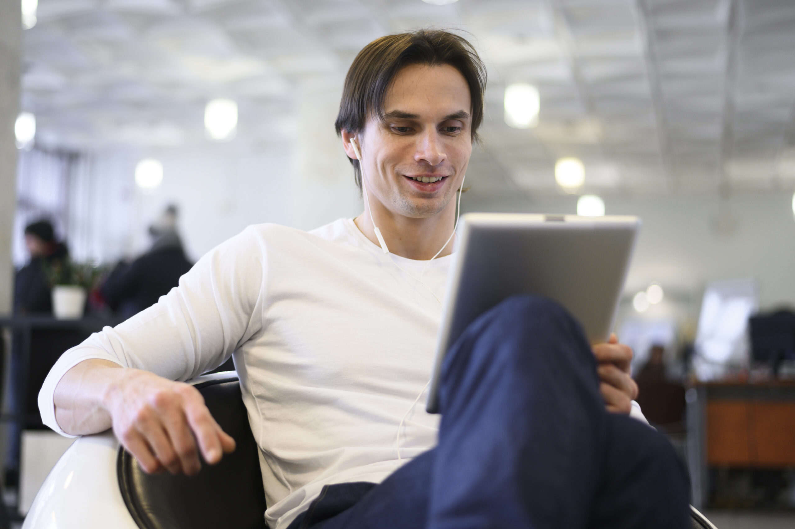 Homem jovem acessando plataforma de investimentos com tablet