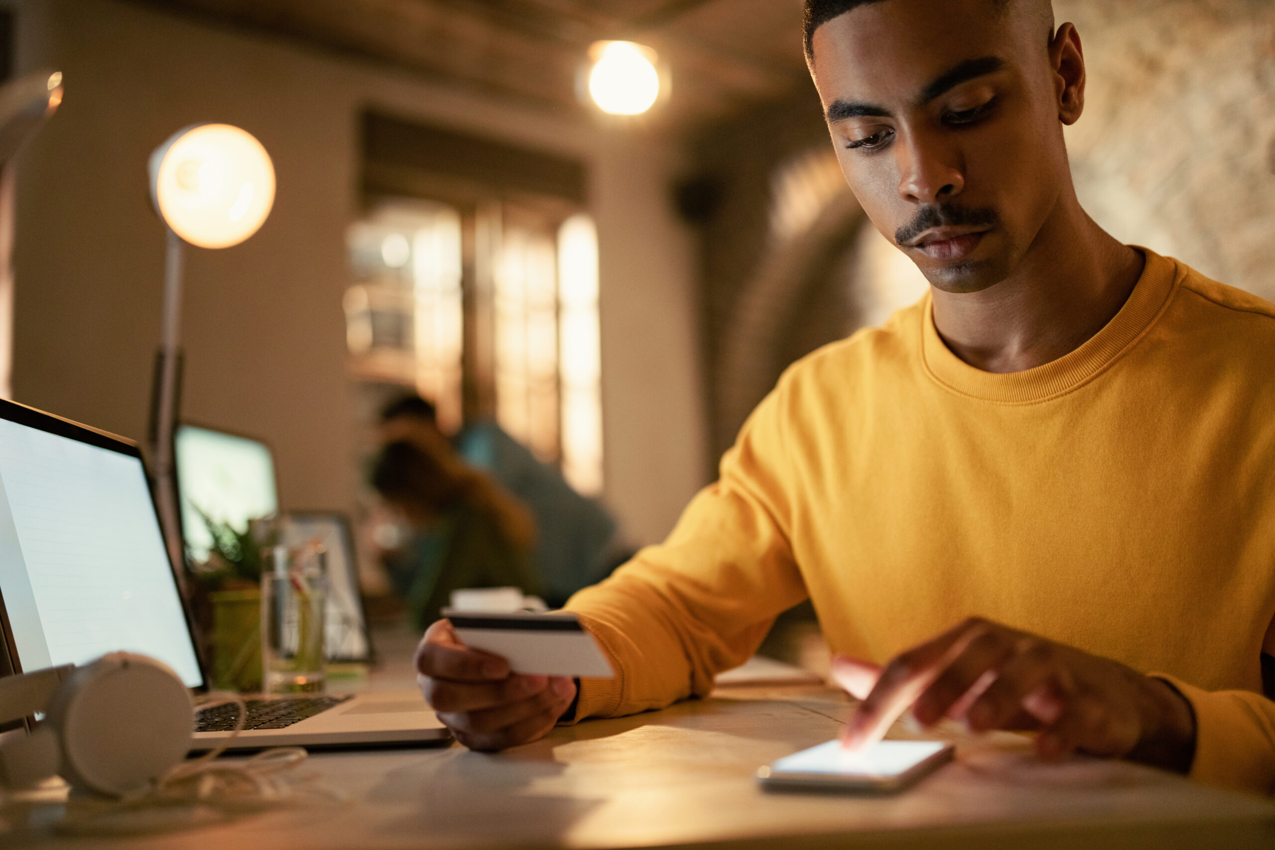 Man using mobile phone and credit card to access digital financial services
